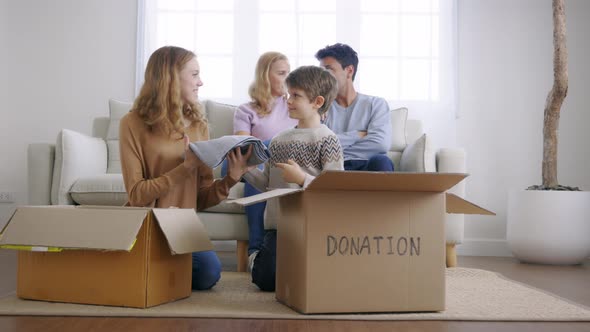 Kids Put Clothes in Cardboard Box