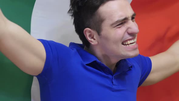 Italian Young Man Celebrating while Holding the Flag of Italy