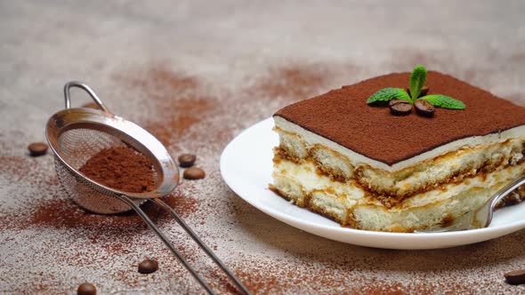 Portion of Traditional Italian Tiramisu dessert on grey concrete background