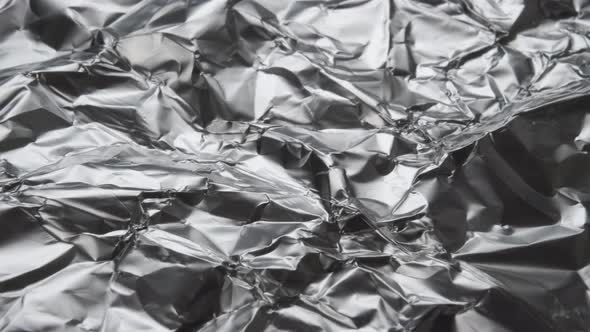 Crumpled wrapping kitchen aluminum shiny foil with wrinkles close-up