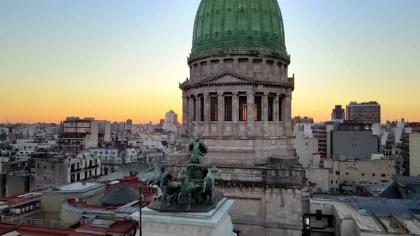 Aerial dolly out of green bronze dome revealing Argentine Congress building at golden hour, Buenos A