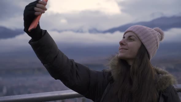 Woman Taking Selfie on Balcony of Highrise