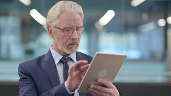 Portrait of Old Businessman Using Digital Tablet