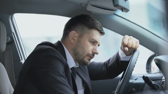 Exhausted Driver Leaning on Steering Wheel to Relax, Stressful Job, Overworking
