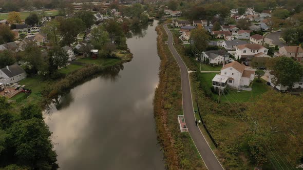 An aerial drone shot over a reflective pond on a cloudy afternoon. The camera dolly in slowly & show