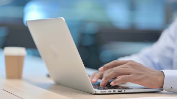 Close Up of African Businessman Typing on Laptop