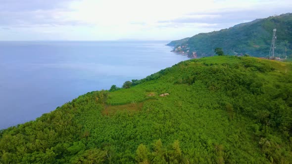 Peaceful Bay View Island Green Grass Plants Blue Sea Flying Across the Mountain Aerial Drone Push-In