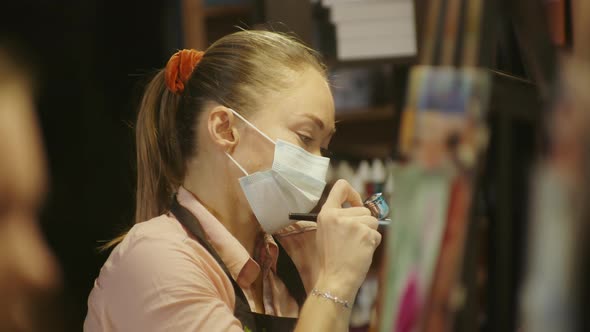 Woman Artist Learns to Paint with Airbrush with Acrylic Dye Paper and Easel