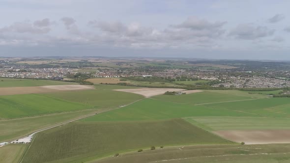 Aerial tracking north from Maiden Castle, the towns of Dorchester and Poundbury is visible in the ba