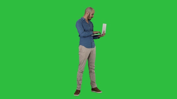 Young middle eastern businessman standing and typing on