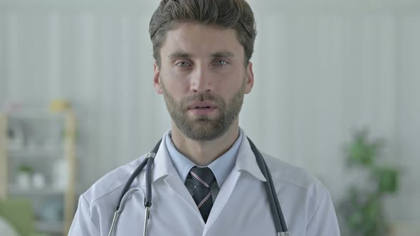 Serious Young Doctor Showing Thumbs Down