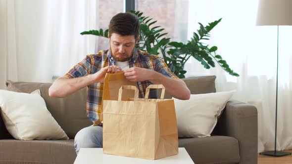 Smiling Man Unpacking Takeaway Food at Home