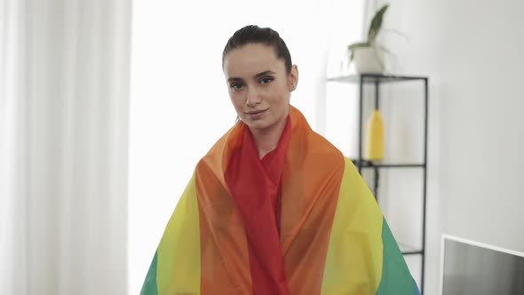 Portrait Young Woman Wearing LGBT Flag Standing at Home. She Looking Into the Camera, Smiling