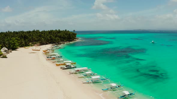 Tropical Daco Island with a Sandy Beach and Tourists