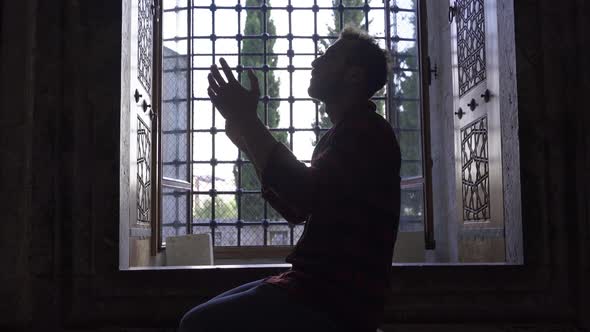 Muslim young man praying to Allah. alt