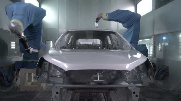 Robotic Arms Spray Painting a Vehicle Body at a Car Manufacturing Factory