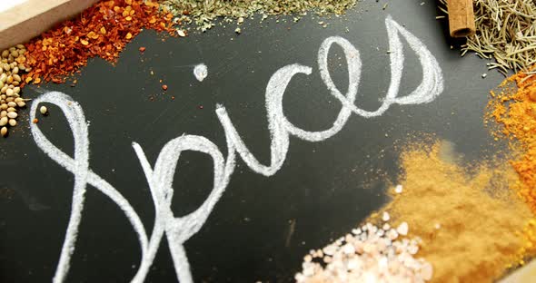 Word spices written on slate with various spices 4k