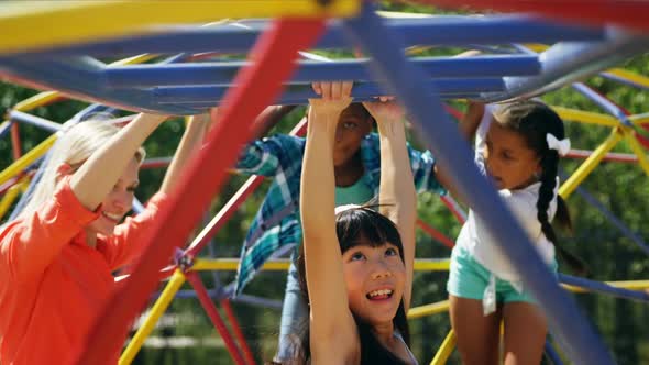 Trainer assisting schoolkids while playing in playground