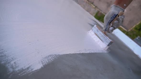 Industrial Climber Paints Wall of Facade with White Paint Using Paintbrush. Slow Motion