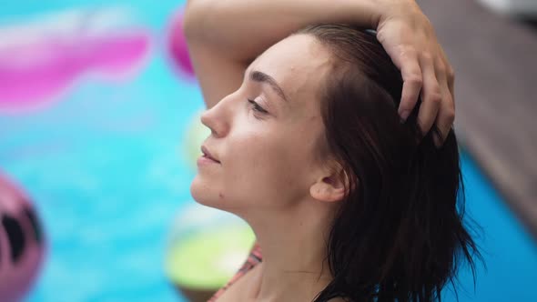 Closeup Side View of Young Caucasian Relaxed Female Tourist Turning to Camera Smiling