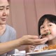 Asian Mother feeding delicious spaghetti  to happy Asian child girl. - VideoHive Item for Sale
