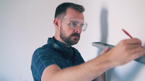 Constructor in Glasses Disappointed of Checking Wall in Room