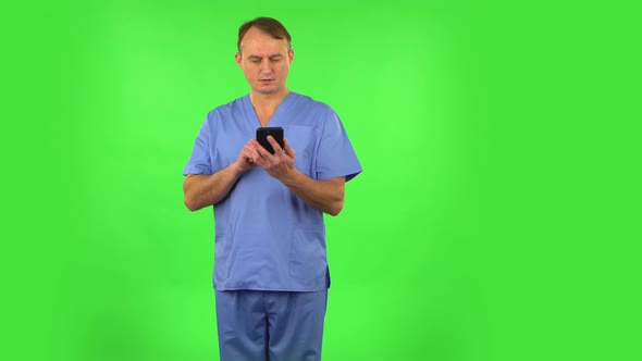 Medical Man Texting on Him Phone. Green Screen