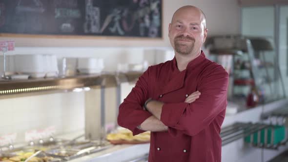 Portrait of Confident Caucasian Man Crossing Hands Smiling Looking at Camera Standing in Self