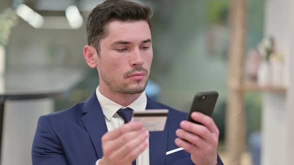 Young Businessman Doing Online Payment on Smartphone 