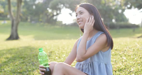 Woman drink of bottle tea in the park 