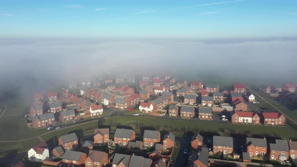 Aerial view of a residential estate covered by fog and clouds