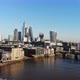 Flying over the Millennium Bridge towards the London's Financial District on a hazy sunny day - VideoHive Item for Sale