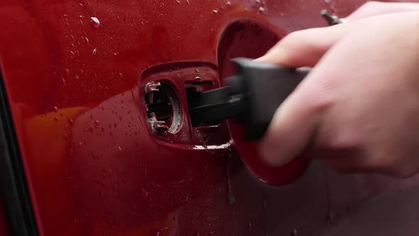 Man is fixing the door handle of his car. Auto repair and maintenance.