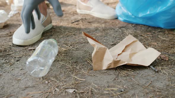 Close-up of Person's Hand Collecting Trash in Park Participating in Clean-up Action