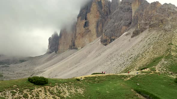 hiking around iconic cloud covered three peaks mountain in Dolomites