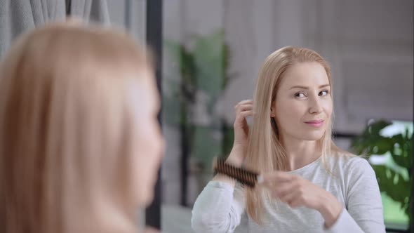 Adult Female Styling Hair in Bathroom