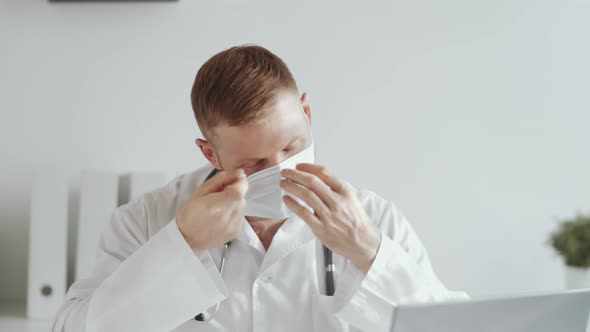 Happy Male Doctor Removing Face Mask and Posing for Camera