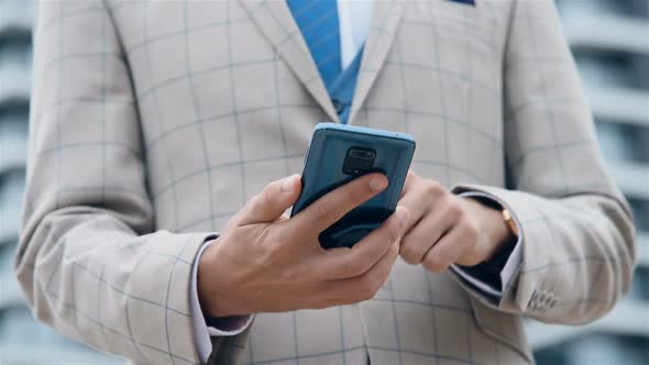 Hands Of Stock Trader Using Mobile Phone