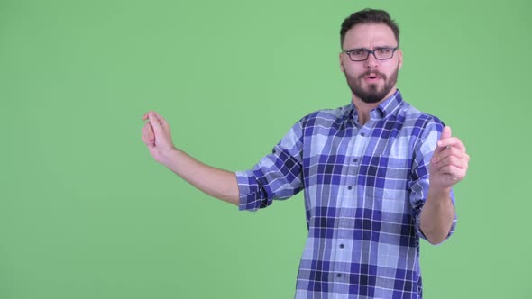 Happy Young Bearded Hipster Man Touching Something and Snapping Fingers