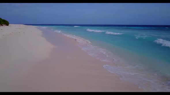 Aerial flying over panorama of luxury seashore beach adventure by blue green water and bright sandy 