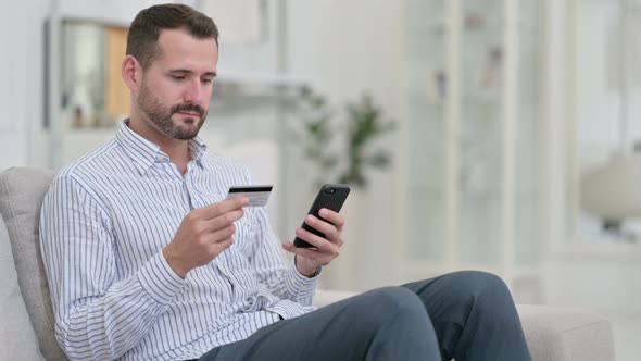 Young Man Making Successful Online Payment on Smartphone