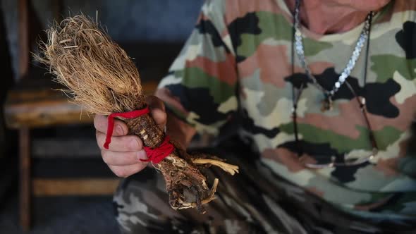 Old male hands with an ancient plant root raskovnik