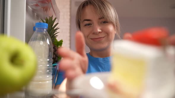 Tired of Diet Woman Eating Cake By Open Fridge