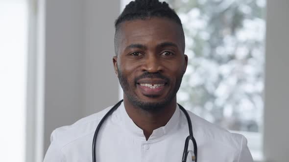 Closeup Portrait of Positive Smiling African American Male Doctor Posing Indoors
