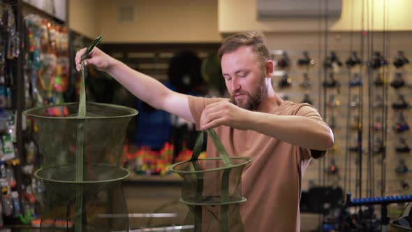 Bearded Man in a Fishing Tackle Shop Getting Ready for a Fishing Trip