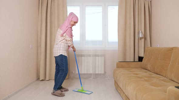 Muslim Woman Doing House Cleaning By Wiping the Floor with a Mop