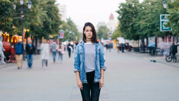 Zoom Out Time-lapse of Beautiful Lady with Dark Hair Standing Alone Among Crowd of People and