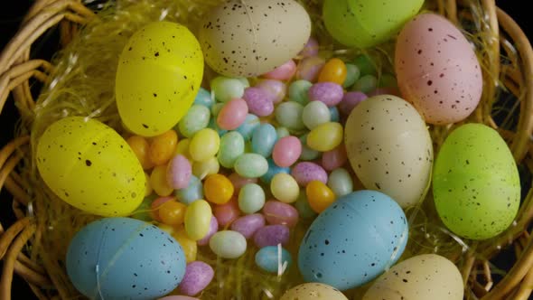 Rotating shot of Easter decorations and candy in colorful Easter grass 