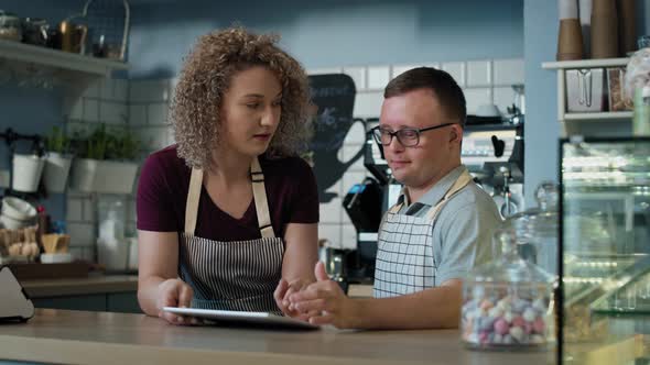 Caucasian man with down syndrome learning how to take orders on digital tablet. Shot with RED helium