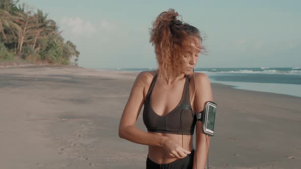 Fitness Girl Putting on Earphones